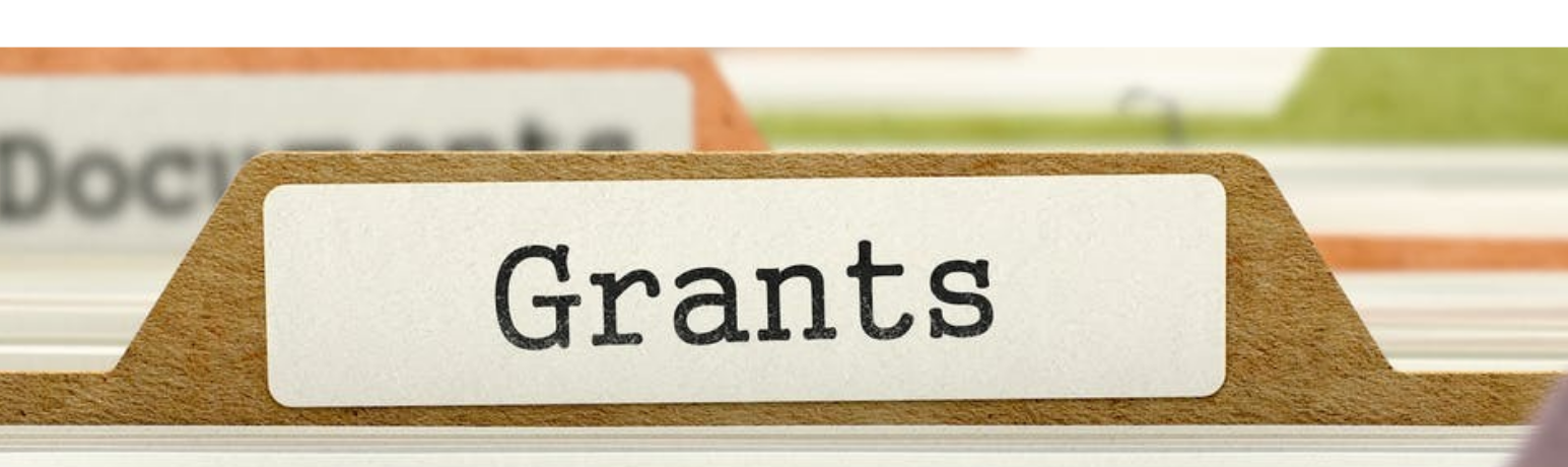 File folders lined up in drawer with front folder table labeled "Grants"