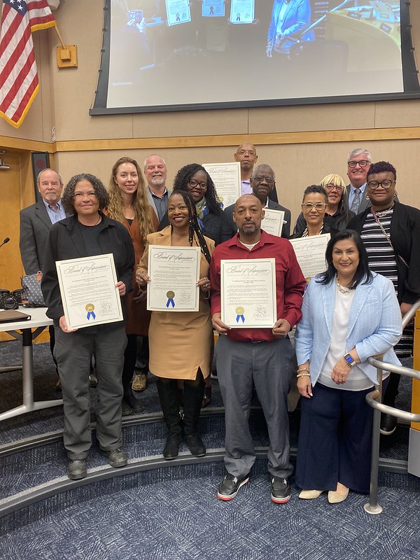 Pictures of community leaders accepting the Black History Month resolution