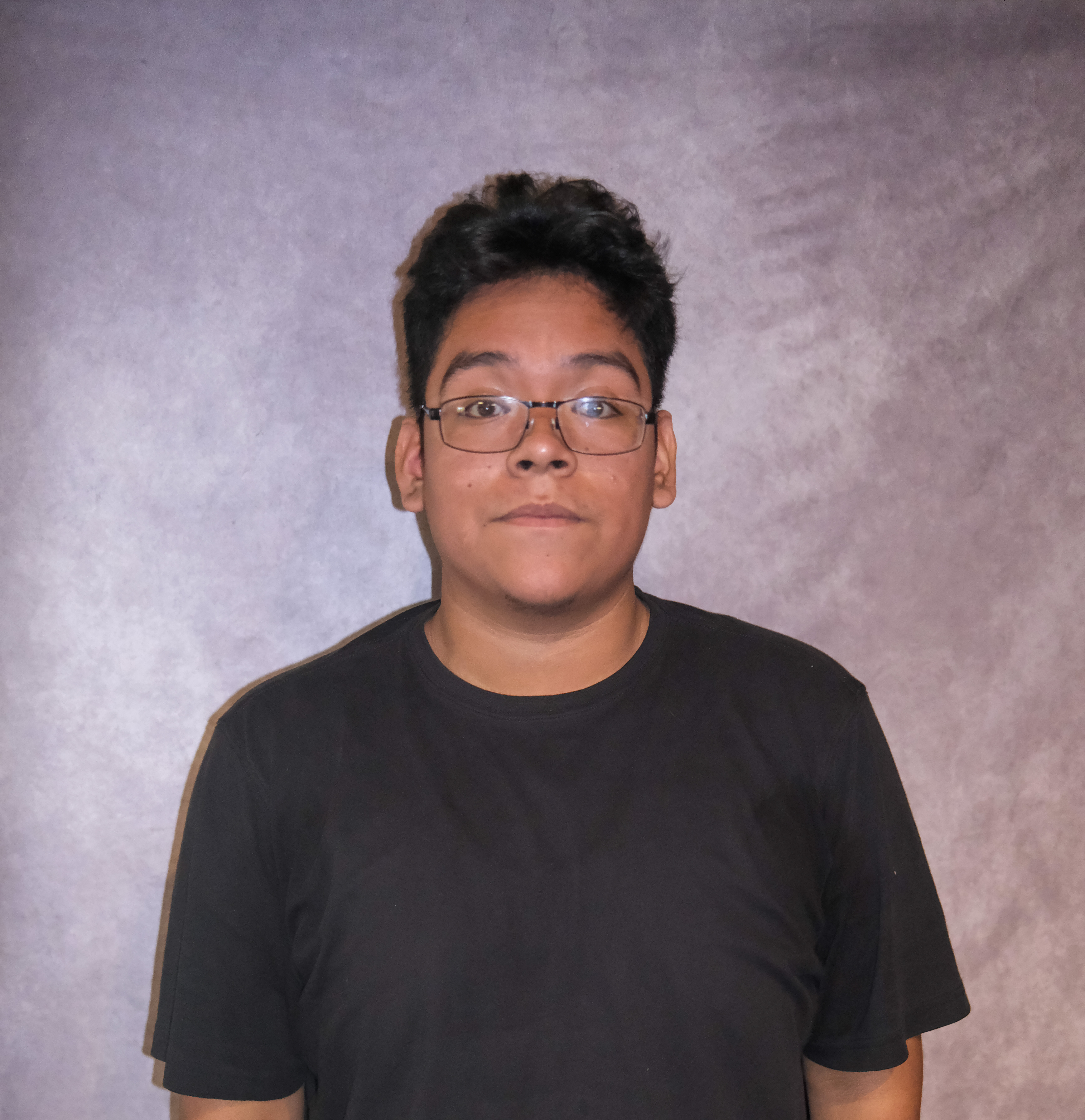 Alejandro posing in front of a gray background