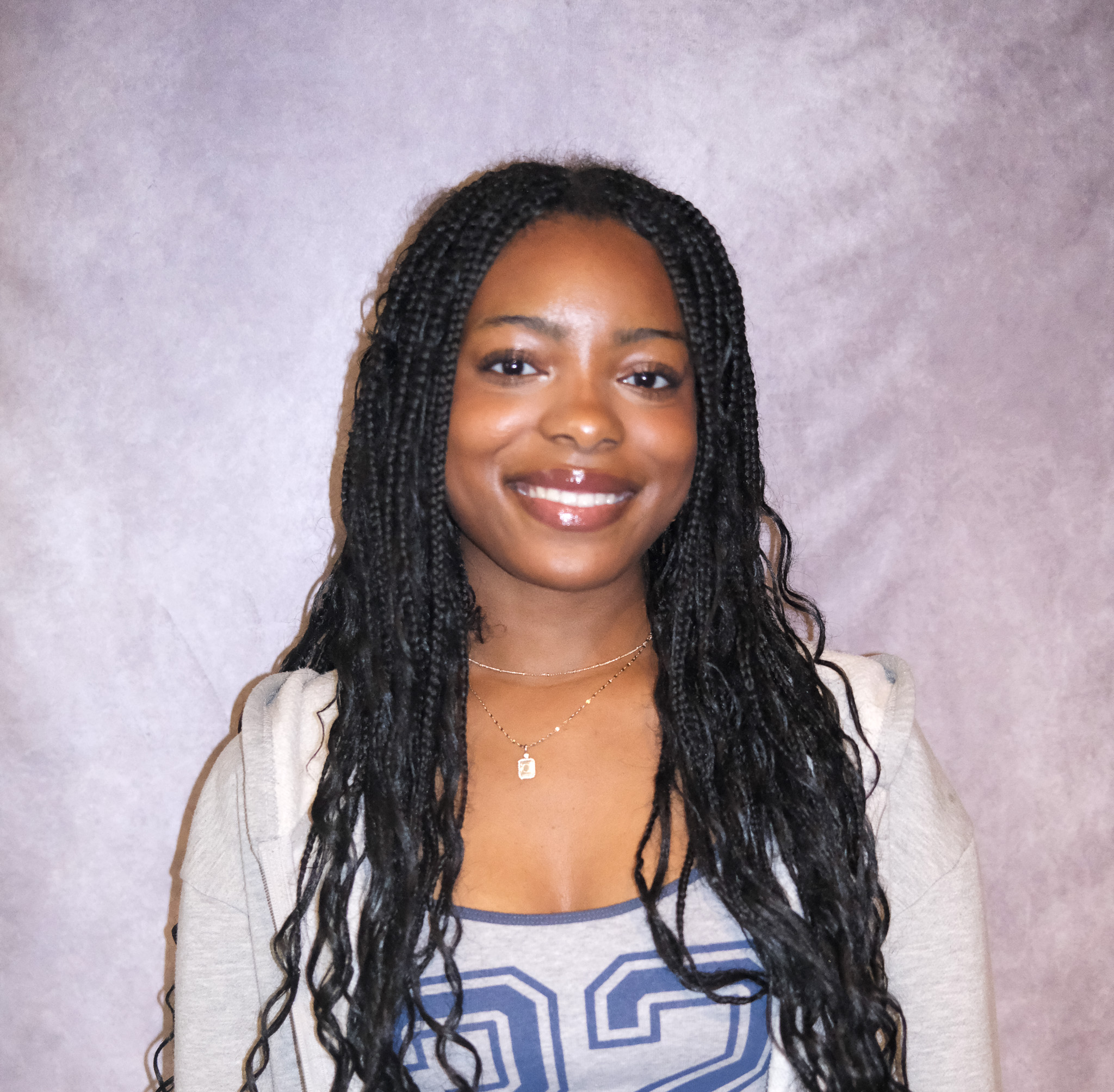 Claire posing in front of a gray background