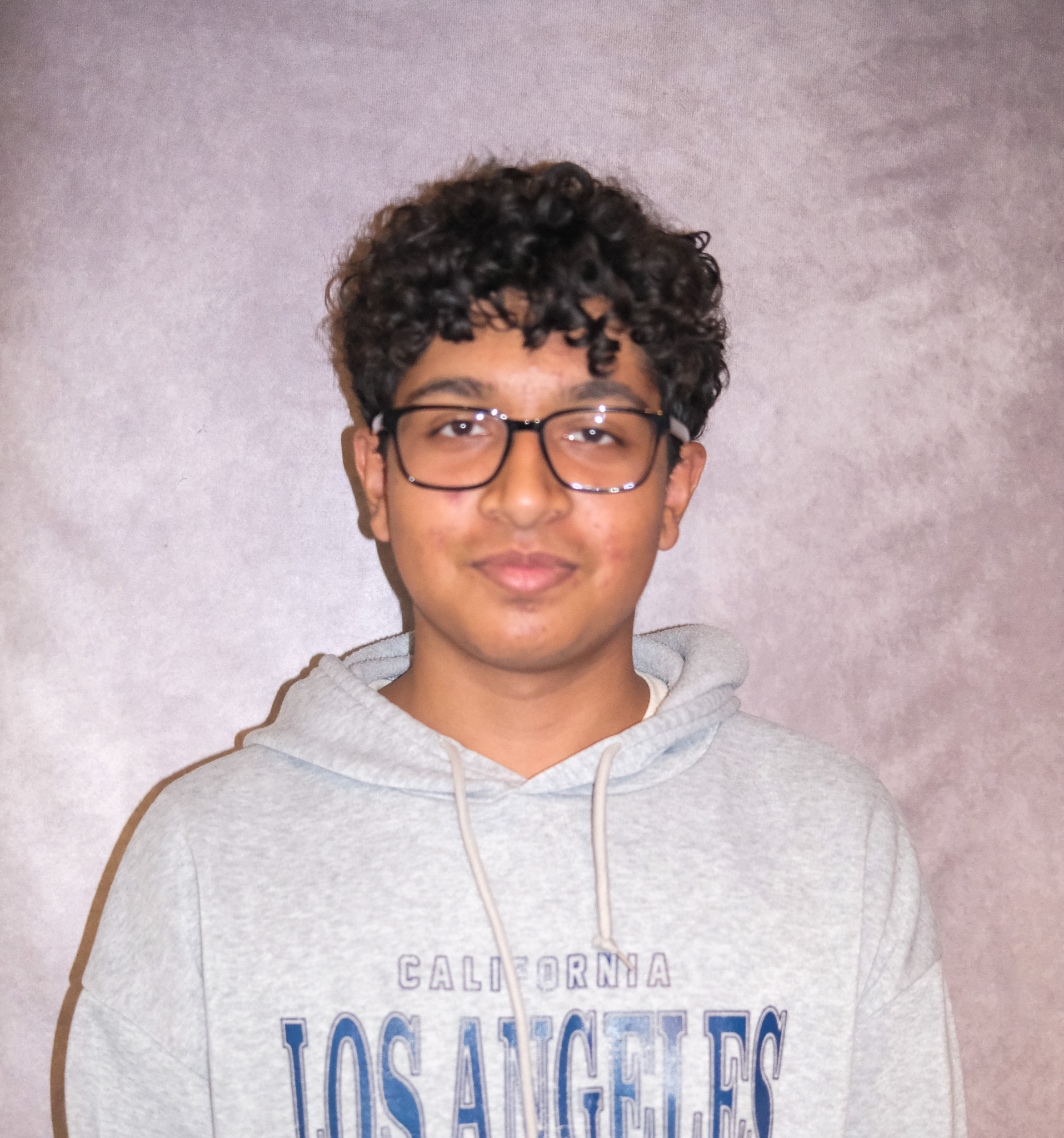 a headshot of Rithik wearing glassed and a gray sweatshirt 
