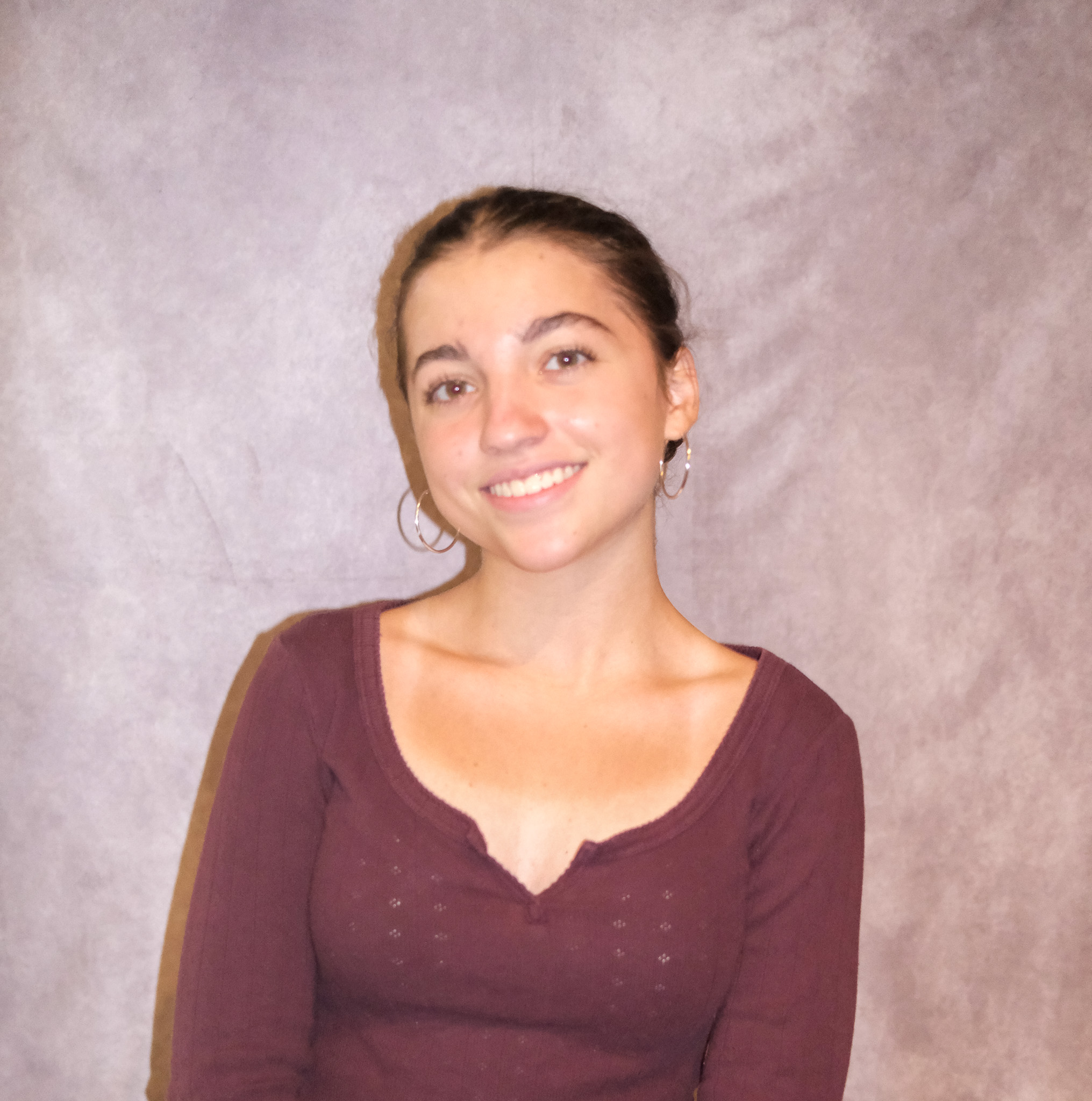 Sophia posing in front of a gray background