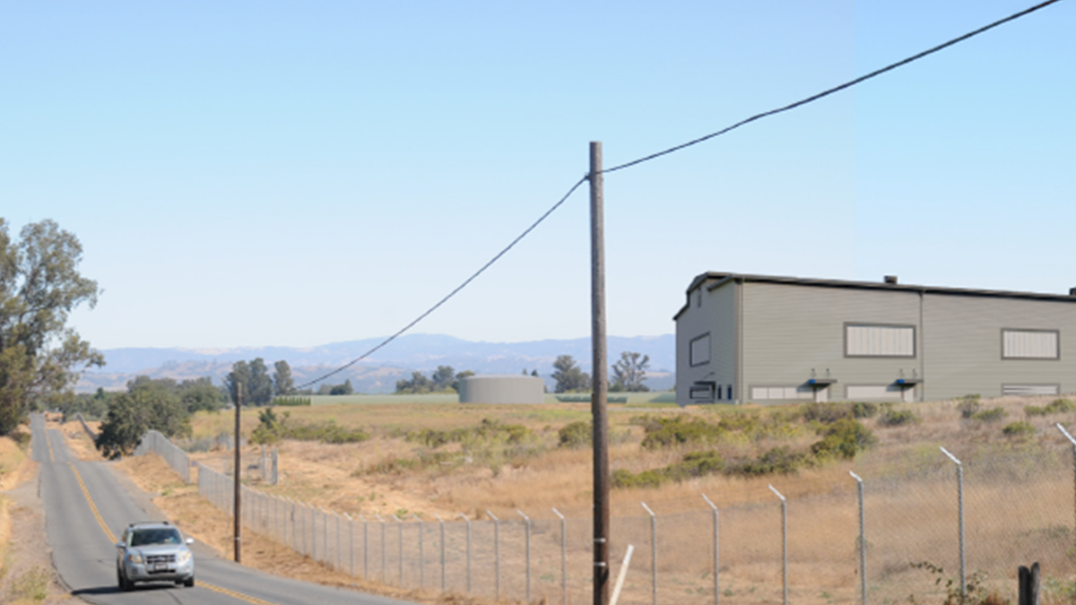 Image of a field with a building in the background.